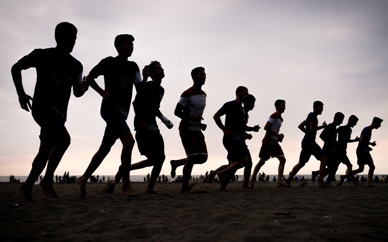 Community runners silhouetted at dusk
